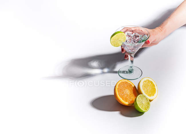 Contrasting shadows from glasses of juicy appetizing orange red yellow green drinks on white background — Stock Photo