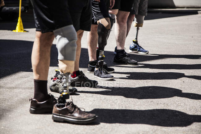 Groupe méconnaissable d'amputés hommes testant leurs nouvelles prothèses de jambe — Photo de stock