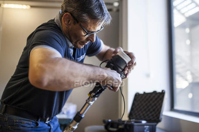 Prosthetic engineer reviewing the prosthesis of a patient and improving the material in his workshop — Stock Photo