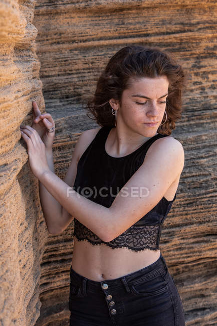 Portrait of slim woman in black crop top standing in canyon — Stock Photo
