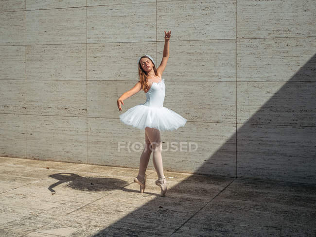 Ballerina in white ballet tutu performing in sunny day — Stock Photo