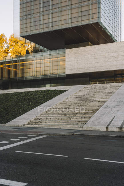 Edifício retangular elegante com escadas de pedra e estrada em dia ensolarado no centro da cidade — Fotografia de Stock