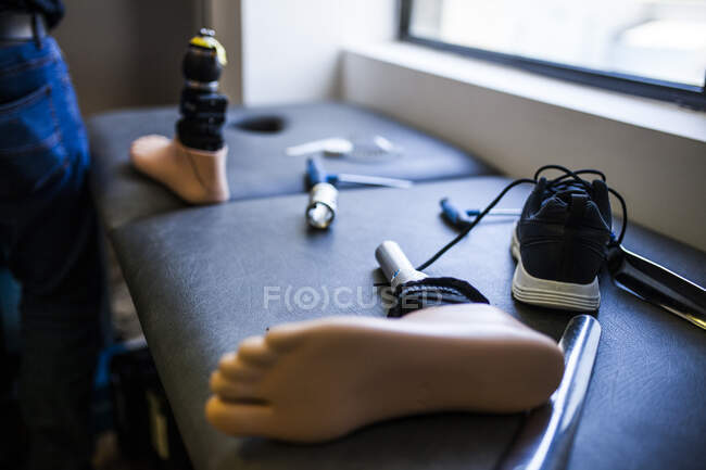Ingeniero protésico irreconocible revisando la prótesis de un paciente y mejorando el material en su taller - foto de stock