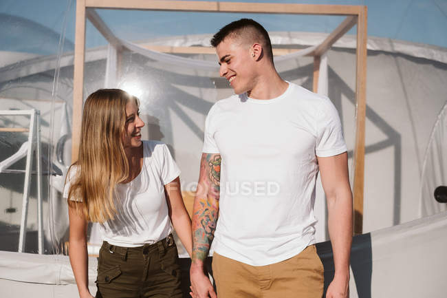 Вид збоку пристрасний чоловік і молода жінка тримає руки перед романтичним прозорим гламуром — стокове фото