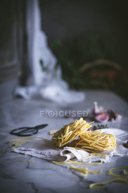 D'en haut pâtes sèches appétissantes sur la nappe sur la table — Photo de stock