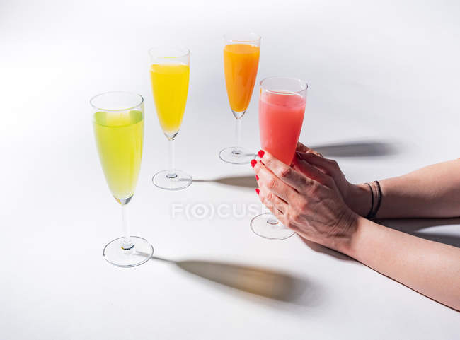 Vaso de mano femenina de jugo sobre fondo blanco - foto de stock