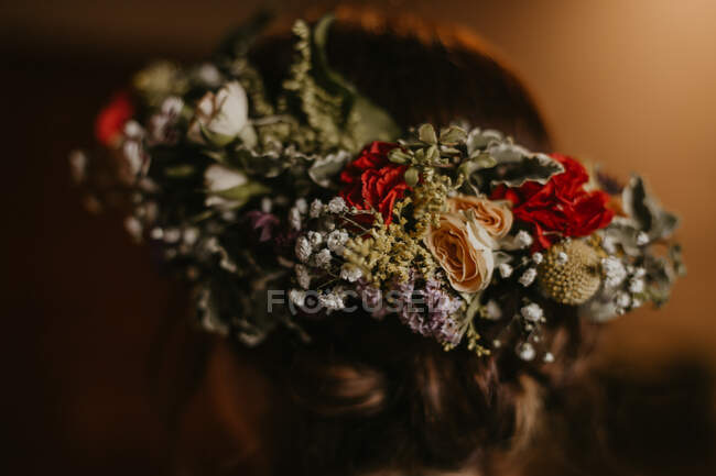 Крупный план элегантный головной убор из различных сушеных цветов на голове неузнаваемой женщины — стоковое фото