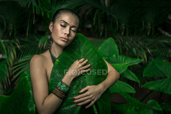 Bella donna in foglie verdi — Foto stock