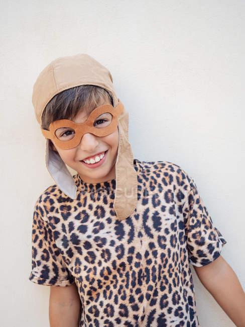 Sonriente lindo niño en gafas decorativas y traje de leopardo mirando a la cámara - foto de stock