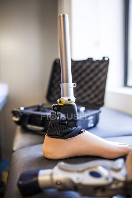 Engenheiro protético irreconhecível revisando a prótese de um paciente e melhorando o material em sua oficina — Fotografia de Stock