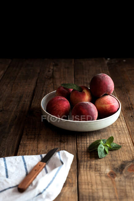 Tasty ripe peaches in plate on table — Stock Photo