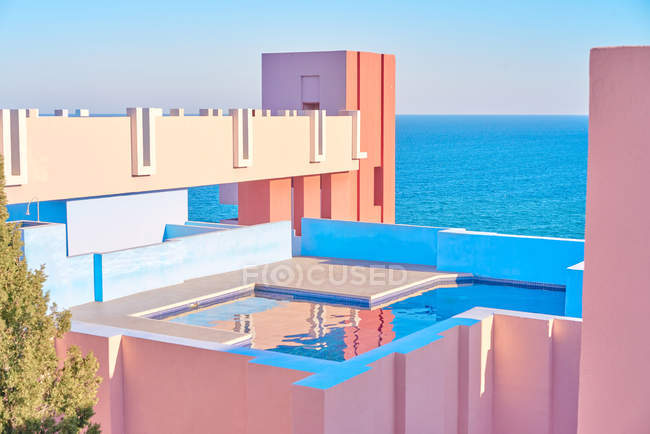 Amazing pool with fresh water reflecting sky on roof of shaped building in bright sunny day — Stock Photo