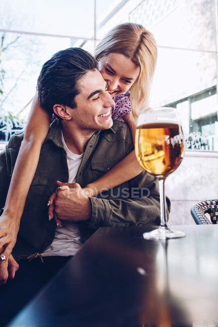 Веселая молодая привлекательная пара, наслаждающаяся освежающим напитком во время прогулки по городу — стоковое фото