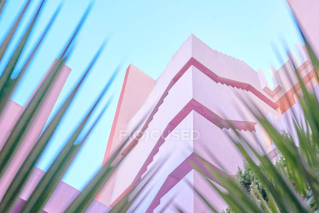 Pink building of complex geometric shape under blue sky — Stock Photo