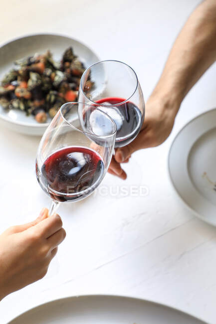 Couple acclamant avec du vin rouge — Photo de stock