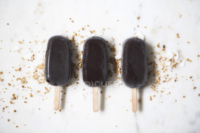 Chocolate ice cream popsicles on marble surface — Stock Photo