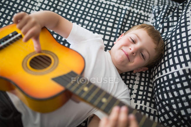 Молодий блондинка грає на іграшковій гітарі. — стокове фото
