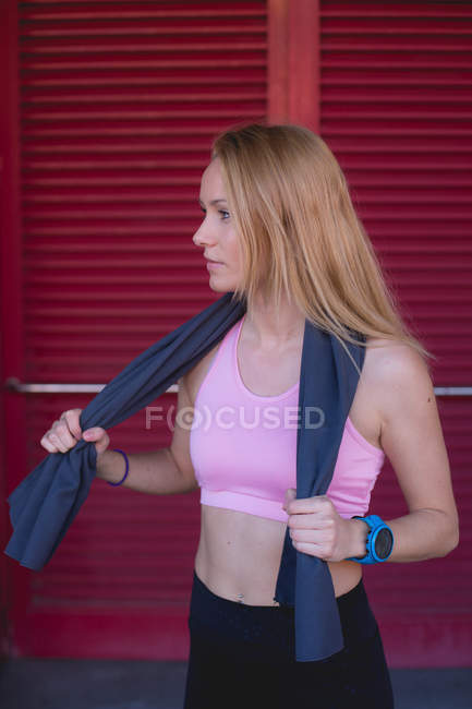 Молода блондинка біла жінка відпочиває від бігової сесії з рушником, загорнутим в шию — стокове фото