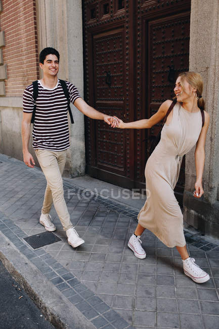 Joven pareja alegre en ropa casual divertirse durante citas al aire libre - foto de stock