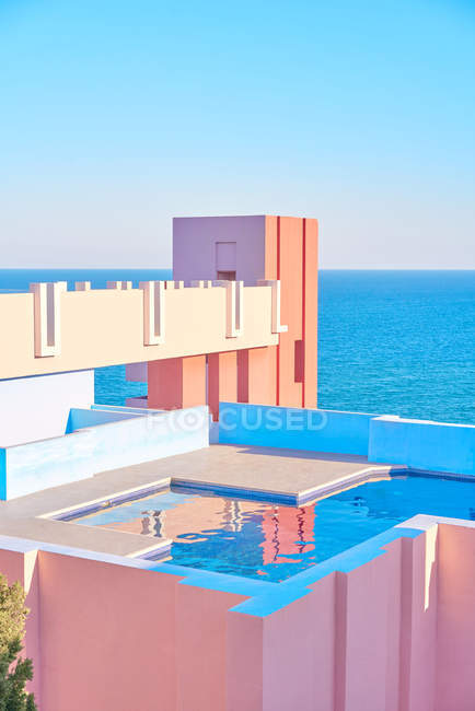 Удивительный бассейн с пресной водой, отражающей небо на крыше здания в яркий солнечный день — стоковое фото