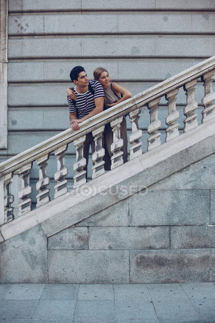 Attractive couple admiring view while standing on old stairs of historical building — Stock Photo