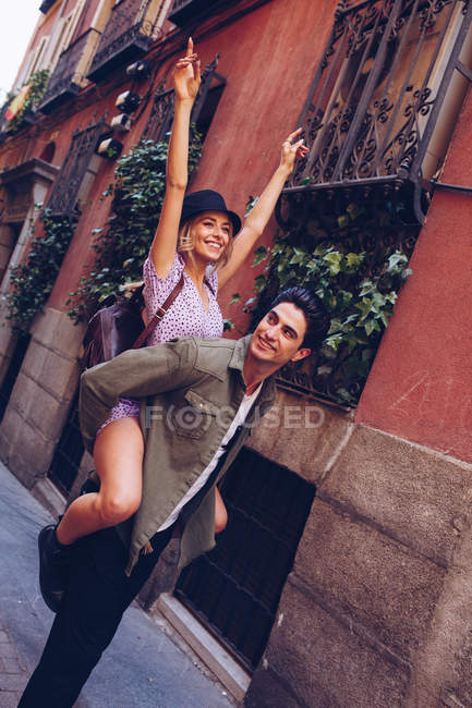 Joven pareja alegre en ropa casual divirtiéndose durante la fecha de la ciudad - foto de stock