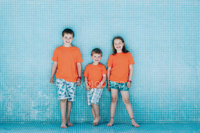 Crianças em pé na piscina vazia e olhando para a câmera — Fotografia de Stock