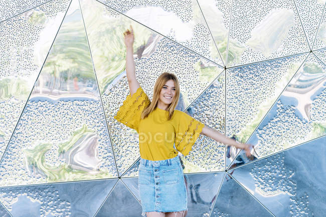Портрет молодой стильной веселой женщины, позирующей на металлическом фоне — стоковое фото