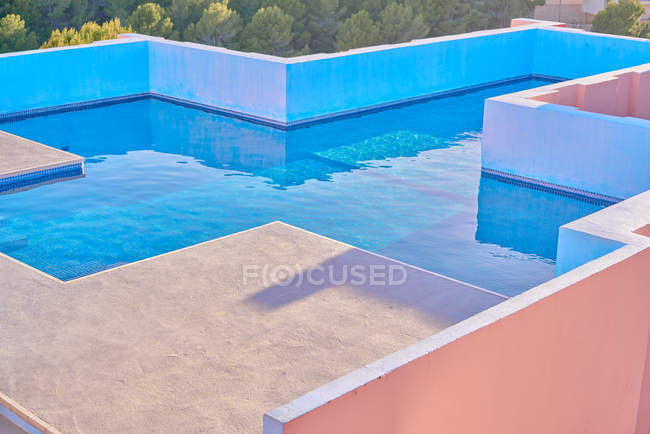Luxurious pool with fresh water on roof of shaped building in bright sunny day — Stock Photo