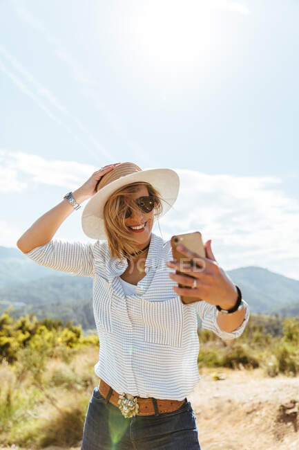 Счастливая девушка смотрит на свой смартфон на закате — стоковое фото