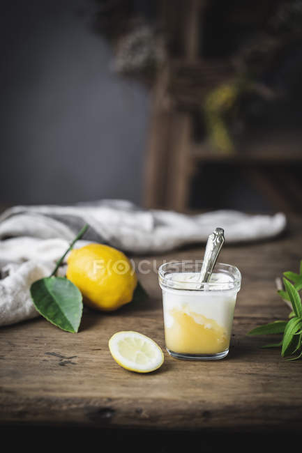 Glass of homemade yoghurt and lemon curd on wooden surface — Stock Photo