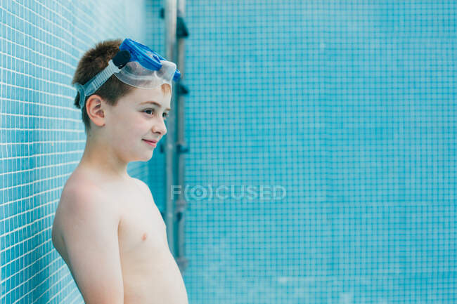 Junge mit Ball steht in leerem Pool — Stockfoto