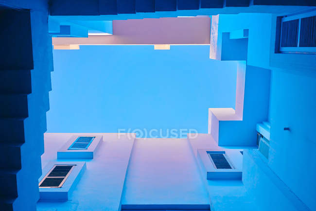De baixo de escadaria geométrica e paredes de edifício na cor azul — Fotografia de Stock