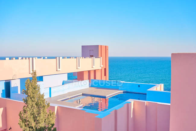 Incredibile piscina con acqua dolce che riflette il cielo sul tetto di edificio a forma di in luminosa giornata di sole — Foto stock