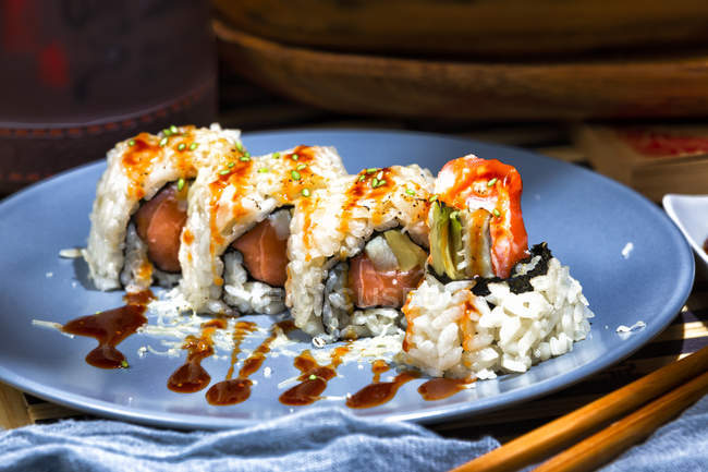 Délicieux sushi coloré appétissant avec sauce rouge et poisson à table servi au restaurant — Photo de stock