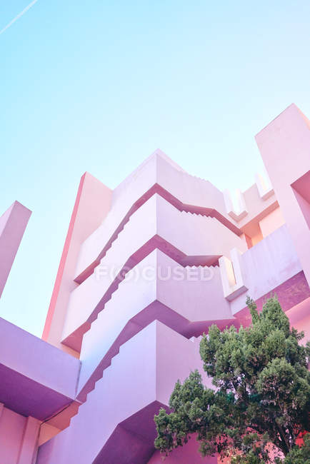 Рожева будівля складної геометричної форми під блакитним небом — стокове фото