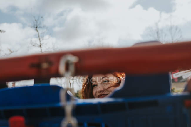 Mujer mirando a través de la rejilla del carro en el carrito de la compra - foto de stock
