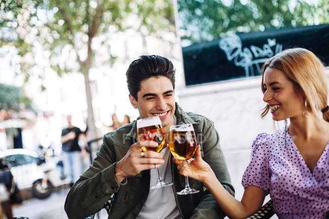 Fröhliches junges attraktives Paar genießt erfrischende Getränke im Stadtcafé — Stockfoto
