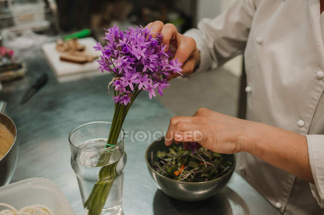 Gemüsesalat mit dunkelgrünem Gemüse in Stahlschüssel und Händen des Chefkochs — Stockfoto