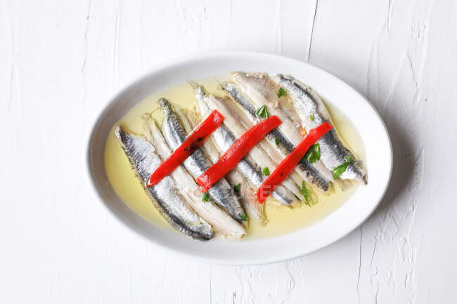 Delizioso piccolo pesce di mare su piatto bianco — Foto stock