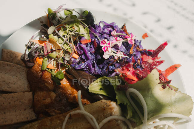 Dall'alto tuffi vegetali rossi arancioni con pane croccante croccante croccante in boccia su cavalletto rotondo sul tavolo — Foto stock