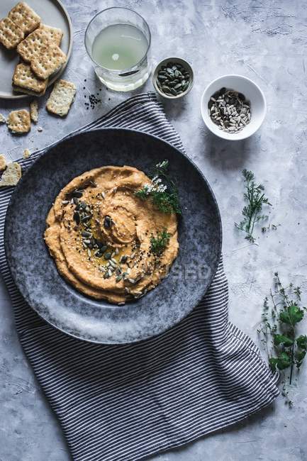De cima chapa com cenoura e grão de bico hummus decorado com sementes — Fotografia de Stock