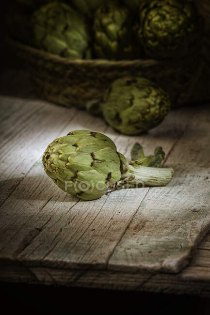 Fresh artichoke on old cracked wooden surface indoors — Stock Photo