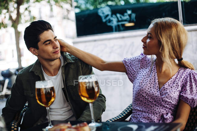 Cheerful young attractive couple enjoying refreshing drinks in cafe — Stock Photo