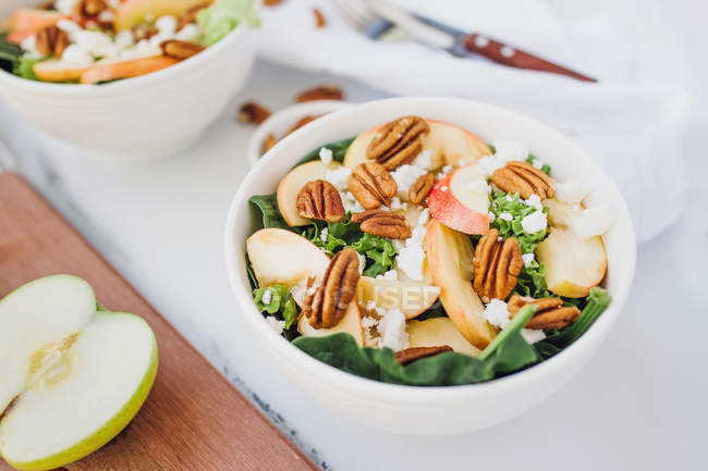 Served bowls with apple and pecan salad on table — Stock Photo
