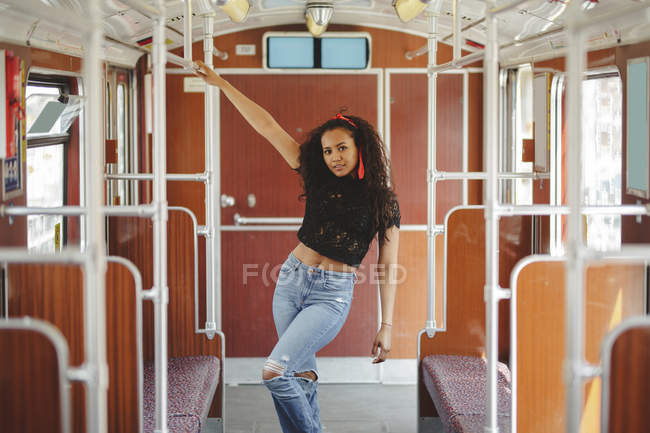 Mulher hispânica alegre no carro de trem em Berlim olhando para a câmera — Fotografia de Stock