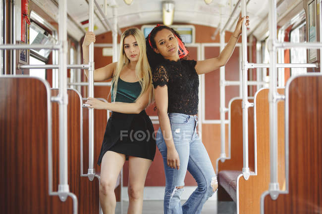Fröhliche, multiethnische Frauen in Berliner Eisenbahnwaggon blicken in die Kamera — Stockfoto