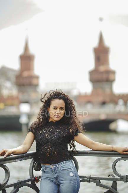 Schönes hispanisches Model lehnt an Geländer an einem Sommertag in Berlin auf verschwommenem Hintergrund und blickt in die Kamera — Stockfoto