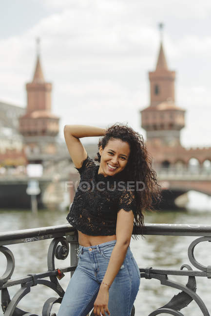 Schönes hispanisches Model lehnt an Geländer an einem Sommertag in Berlin auf verschwommenem Hintergrund und blickt in die Kamera — Stockfoto