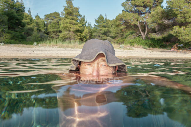 Front du nageur complètement immergé dans l'eau en regardant la caméra par temps ensoleillé, Halkidiki, Grèce — Photo de stock